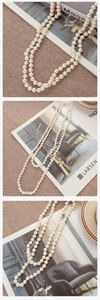 Close-up of elegant double-layer long pearl necklace on a textured linen surface