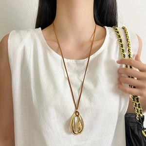 Elegante collana con ciondolo ovale dorato e cordino in pelle marrone per abiti donna