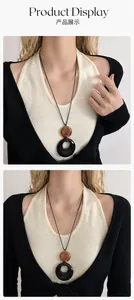 Gros plan du pendentif anneau noir et ambre sur collier cordon noir au style minimaliste