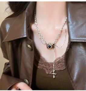 Dettaglio del ciondolo fotocamera vintage e nappa croce su collana in argento