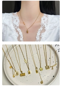 Detailed view of gold Fu character and horse pendants on titanium steel necklace
