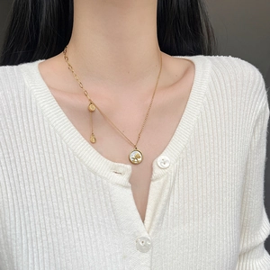 Golden titanium steel necklace with asymmetric chain and horse medallion on a model