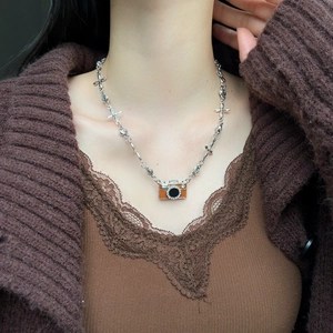 Braune Kamera-Halskette mit silberner Kette am Model im modischen Retro-Stil