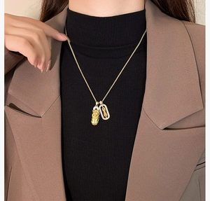 Golden Pixiu and diamond-set oval double pendant necklace shown on a model