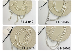 Gedetailleerd overzicht van vier lange parelkettingen met elegante hangerontwerpen