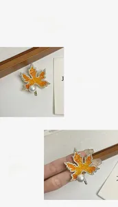 Détails de la broche feuille d'érable avec cristaux orange, zircons et perle blanche