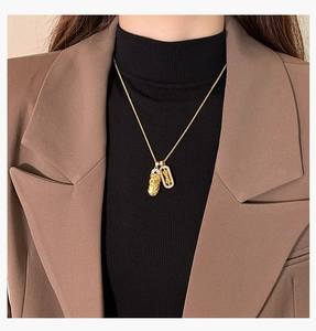 Golden Pixiu pendant necklace with Zhaocai engraving worn on a brown blazer outfit