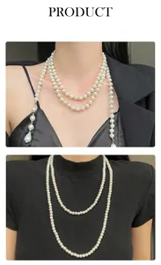 Detail van lange gelaagde parelketting met gouden kralen en een druppelvormige hanger