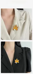 Détail macro de broche feuille d'érable avec zircon orange, cadre doré et perle