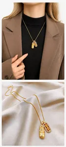 Detailed close-up of golden Pixiu and Vajra pendants on silk fabric and model wear
