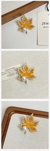 Vue détaillée de la broche feuille d'érable avec cristaux orange et perle élégante