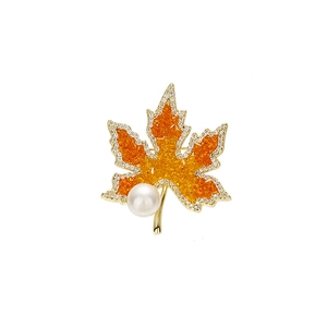 Broche feuille d'érable en cristaux orange et perle blanche sur monture dorée