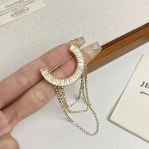 Exquisito broche con borlas de circón chapado en oro con diseño de media luna