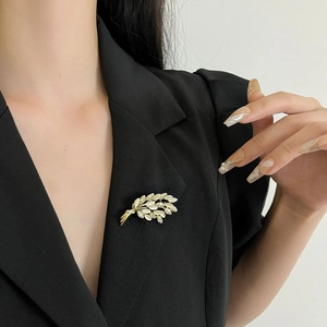 Broche épi de blé dorée élégante avec feuilles d'opale et strass sur un costume noir