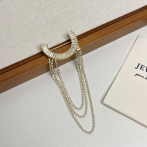 Broche de borlas bañado en oro con cristales baguette y cadenas de flecos brillantes