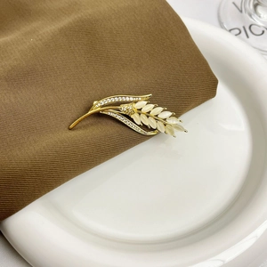 Elegante gouden tarwe-aar broche met kattenoogsteen en fonkelende kristallen op bruine stof