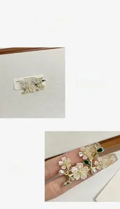 Detail showing high-quality micro-pave zircons and white pearl on the gold floral brooch