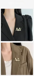 Floral pearl brooch pinned on black and brown suit jackets for style display