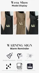 Detailed view of floral pearl brooch with green enamel leaves on a black suit lapel