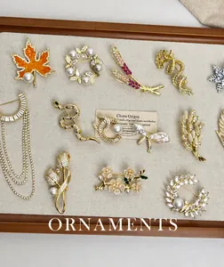 Detaillierte Sammlung vergoldeter Broschen mit Zirkonia und Perlen auf einem Display