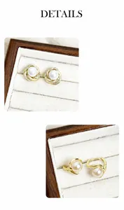 Détail de boucles d'oreilles spirales dorées avec perle et zircons scintillants