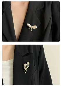 Gros plan sur une broche tulipe dorée avec cristaux micro-pavés et détail perle