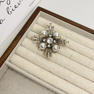 Broche de cruz dorado vintage con perlas elegantes y cristales brillantes en un estuche