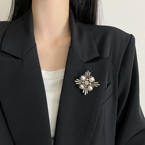 Broche vintage estrella con perlas y strass en la solapa de una chaqueta negra