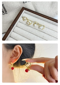 Détail de boucles d'oreilles perles et boucles d'oreilles baies rouges en argent S925