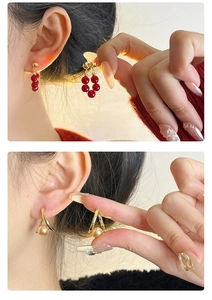 Détail de boucles d'oreilles en perles rouges et clous triangle dorés pour femmes