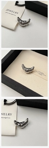 Macro shot of S925 sterling silver croissant brooch with textured ribbed metal details