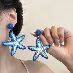 Exaggerated woven starfish earrings in blue and white, perfect for summer beach vacations