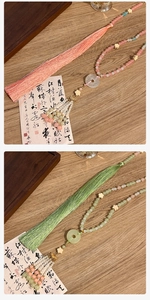 Dettaglio di nappe cinesi tradizionali con perle di giada e frange di seta su legno