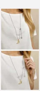 Detail of adjustable long sweater necklace with textured golden croissant pendant charms