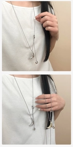 Detail of gold and silver croissant moon pendant on a long Y-shaped adjustable necklace