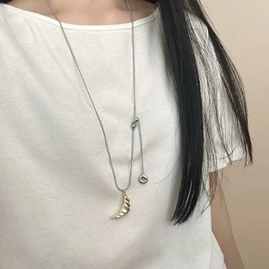Minimalist croissant donut pendant long necklace in golden finish on white t-shirt