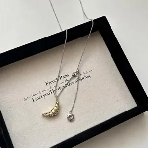French style gold croissant pendant necklace on silver chain for elegant sweater styling