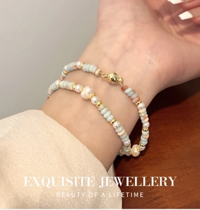 Detalle de pulsera de doble capa con piedras naturales, perlas y cierre magnético dorado