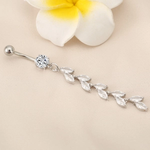 Macro detail of silver belly ring with marquise zircon leaf tassels and curved barbell