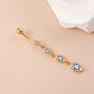 Dettaglio di un piercing all'ombelico dorato con quattro zirconi con taglio marquise