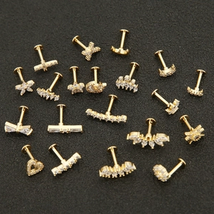 Golden labret studs set with CZ stones in star, moon, and heart shapes for ear piercings