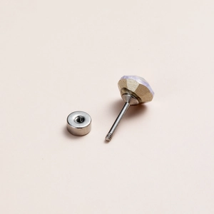 Detailed macro of a crystal stud earring with flat back screw and iridescent plating