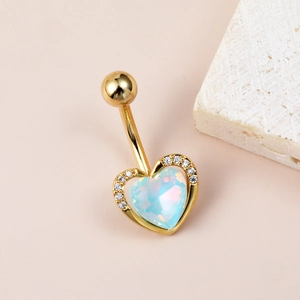 Detailed view of golden heart-shaped belly ring with aurora center stone and zircon accents