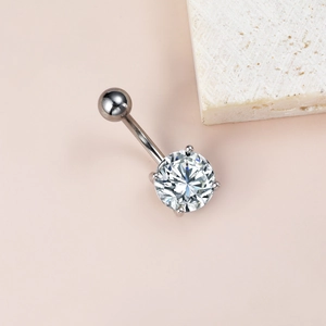 Gros plan d'un piercing de nombril en acier avec un grand oxyde de zirconium rond serti à griffes