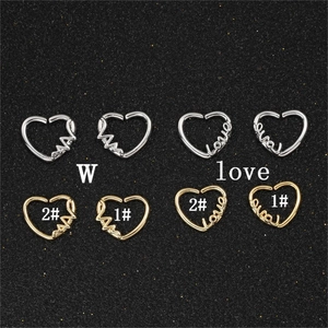 Macro di orecchini a cuore in oro e argento con incisione love e design a linee di impulsi
