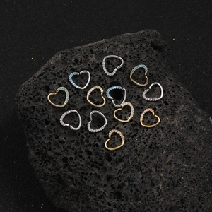 Micro heart piercing jewelry set with zircon in gold, silver, and rose gold on black stone