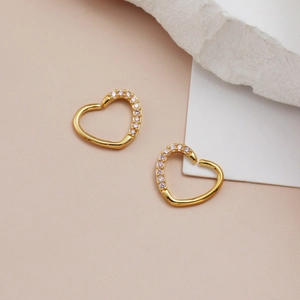 Golden heart-shaped ear studs with pink cubic zirconia pavé stones for a luxury aesthetic