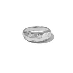 Minimalistischer silberner Dom-Ring mit funkelnden Sternen und polierter Oberfläche