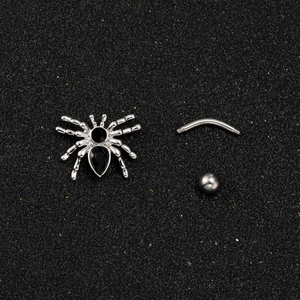 Detailed view of silver spider belly ring components with black zircon inlay on a dark base