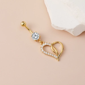 Elegant gold-plated heart navel ring with sparkling cubic zirconia on a minimalist background